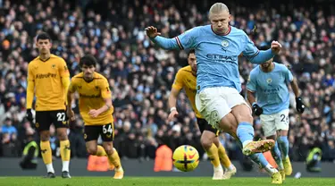 Penyerang Manchester City, Erling Haaland melakukan tendangan penalti dan mencetak gol kedua timnya ke gawang Wolves selama pertandingan lanjutan Liga Inggris di Stadion Etihad di Manchester, Inggris (22/1/2023). Manchester City menang telak atas Wolves 3-0. (AFP/Paul Ellis)