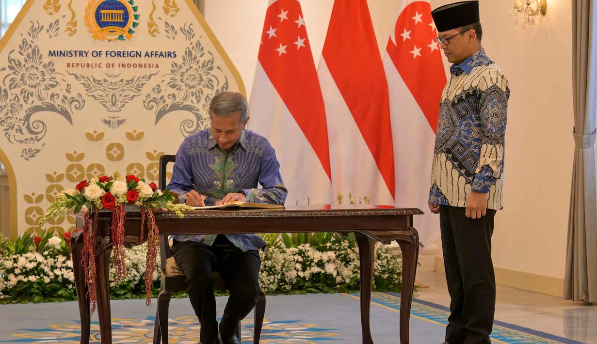 Dalam pernyataannya, Menteri Luar Negeri RI Sugiono menekankan pentingnya penguatan koordinasi antara Indonesia dan Singapura dalam menghadapi dinamika global yang berdampak pada ekonomi dan kawasan. Tampak dalam foto, Menteri Luar Negeri Indonesia Sugiono (kanan) menyaksikan Menteri Luar Negeri Singapura Vivian Balakrishnan mengisi buku tamu selama pertemuan mereka di Gedung Kementerian Luar Negeri, Jakarta pada Selasa 12 Mei 2026. (BAY ISMOYO/AFP)