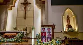 Potret para korban bom bunuh diri terlihat saat orang-orang menghadiri upacara peringatan di Gereja Katolik Santa Maria, Surabaya, Jawa Timur, pada 13 Mei 2025. (Juni KRISWANTO/AFP)