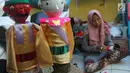 Perajin menyelesaikan pembuatan miniatur ondel-ondel di rumah produksi Kramat Jati, Jakarta, Senin (23/6/2019). Perajin bisa mengumpulkan omzet mencapai Rp 5 juta hingga Rp 8 juta per bulan. (merdeka.com/Arie Basuki)