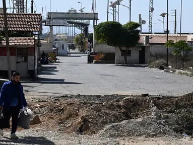 Foto menunjukkan lubang yang disebabkan oleh serangan Israel di jalan menuju penyeberangan perbatasan Jousieh, Suriah, dengan Lebanon pada 28 Oktober 2024. (LOUAI BESHARA/AFP)