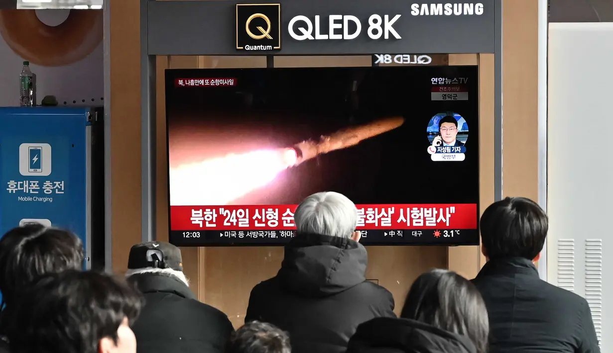 Orang-orang menonton layar televisi yang menampilkan siaran berita dengan file rekaman uji coba rudal Korea Utara, di sebuah stasiun kereta api di Seoul pada 28 Januari 2024. (Jung Yeon-je/AFP)