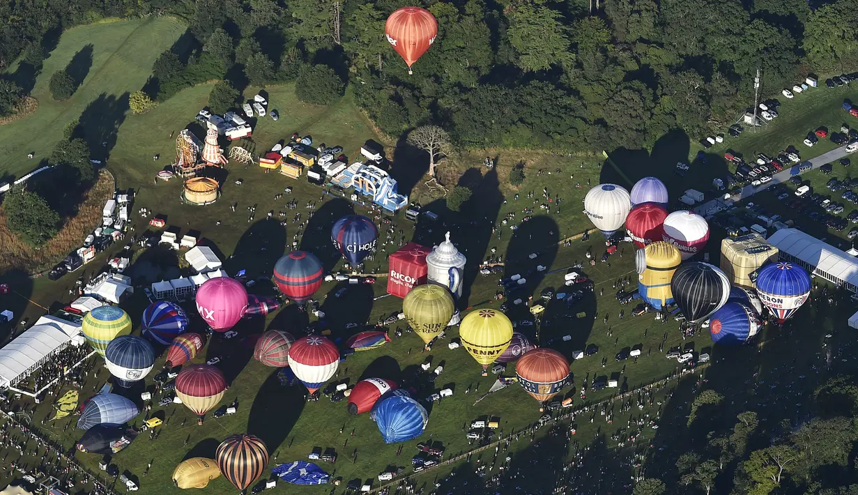 Sejumlah balon udara bersiap untuk diterbangkan di Bristol International Balloon Fiesta ke 37  di Inggris, Jumat (7/8/2015). Festival balon terbesar di eropa ini berlangsung selama empat hari.  (REUTERS/Toby Melville)