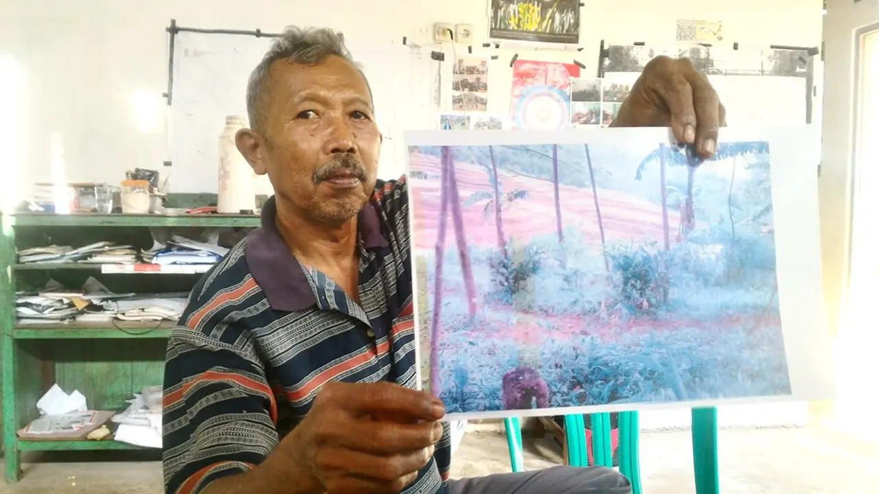 Direktur LSM Setam, Petrus Sugeng memperlihatkan foto tanah yang disengketakan antara warga Wanareja dengan Perhutani. (Foto: Liputan6.com/Muhamad Ridlo).