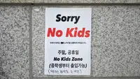 Foto yang diambil pada 20 Juli 2023 ini menunjukkan tanda 'No Kids Zone' di pintu masuk sebuah kafe di Seoul. Di negara dengan tingkat kelahiran terendah di dunia, munculnya semakin banyak fasilitas yang melarang anak-anak, seperti kafe, perpustakaan, dan galeri seni, membuat marah para orangtua, seperti anggota parlemen Korea Selatan Yong Hye In. (Yelim LEE/AFP)