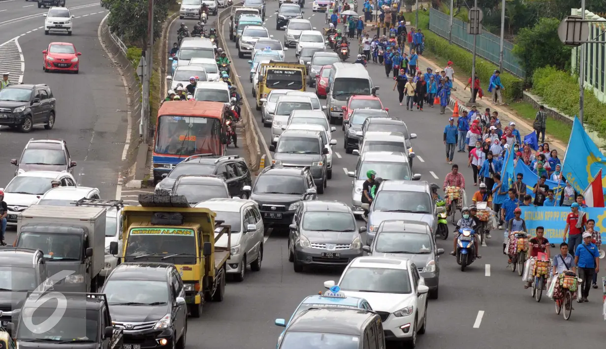 Sejumlah buruh berjalan menuju Gedung DPR RI, Jakarta, Minggu (1/5) Lalu lintas menjadi tersendat imbas dari Hari Buruh Internasional yang jatuh pada 1 Mei. (Liputan6.com/Helmi Afandi)