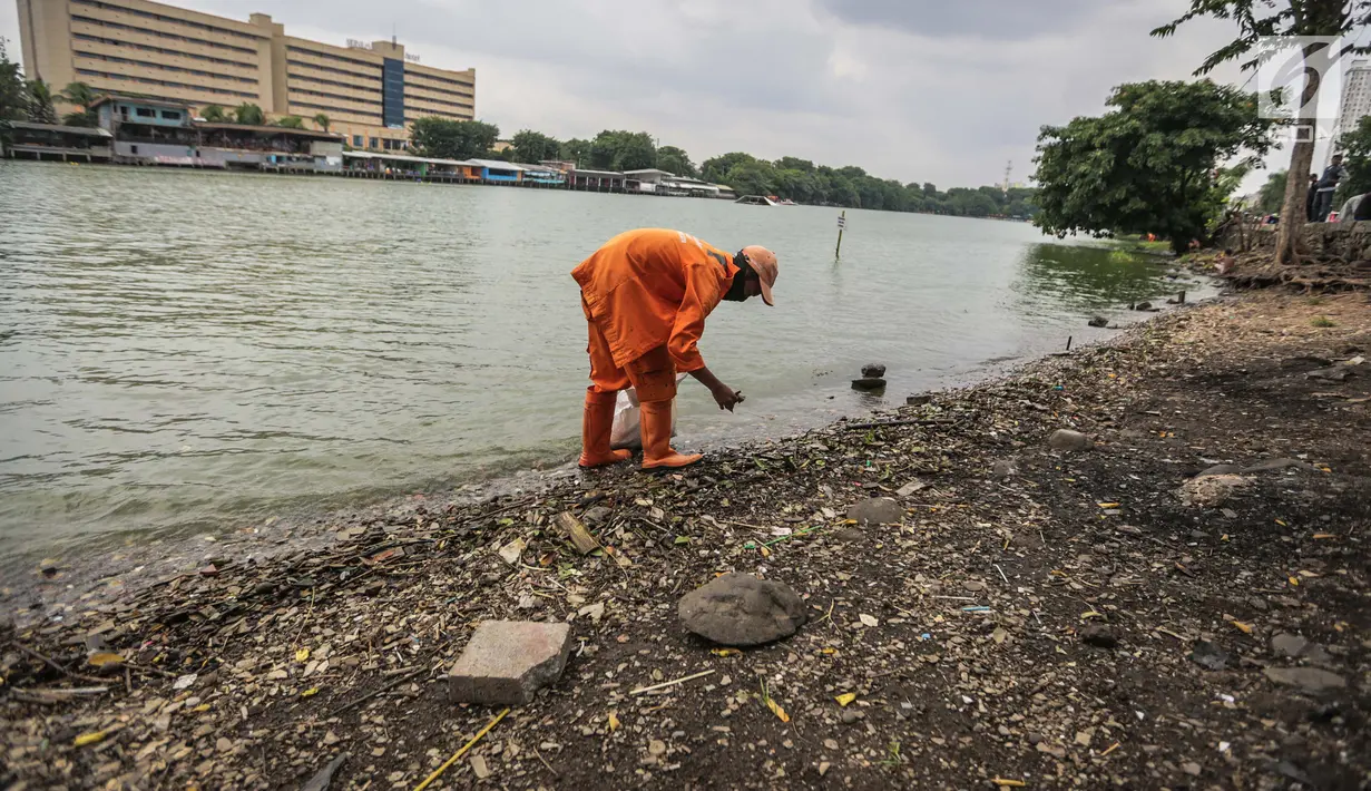 Pasukan oranye memunguti daun kering dan sampah di pinggiran Danau Sunter, Jakarta, Rabu (27/12). Aksi bersih-bersih itu terkait rencana kegiatan pesta malam tahun yang akan digelar Pemkot Jakarta Utara di danau Sunter. (Liputan6.com/Faizal Fanani)