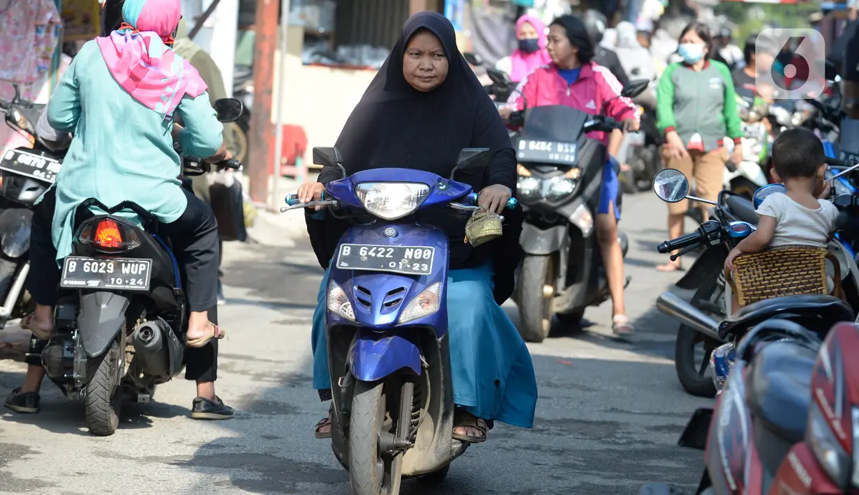 Pengendara motor tidak mengenakan masker masuk ke Pasar Bukit di Tangerang Selatan, Banten, Rabu (22/7/2020). Warga masih tidak peduli kesehatan dirinya sendiri dan orang lain, tentang bahayanya penyeberan virus corona (COVID-19) yang terus meningkat di Indonesia. (merdeka.com/Dwi Narwoko)
