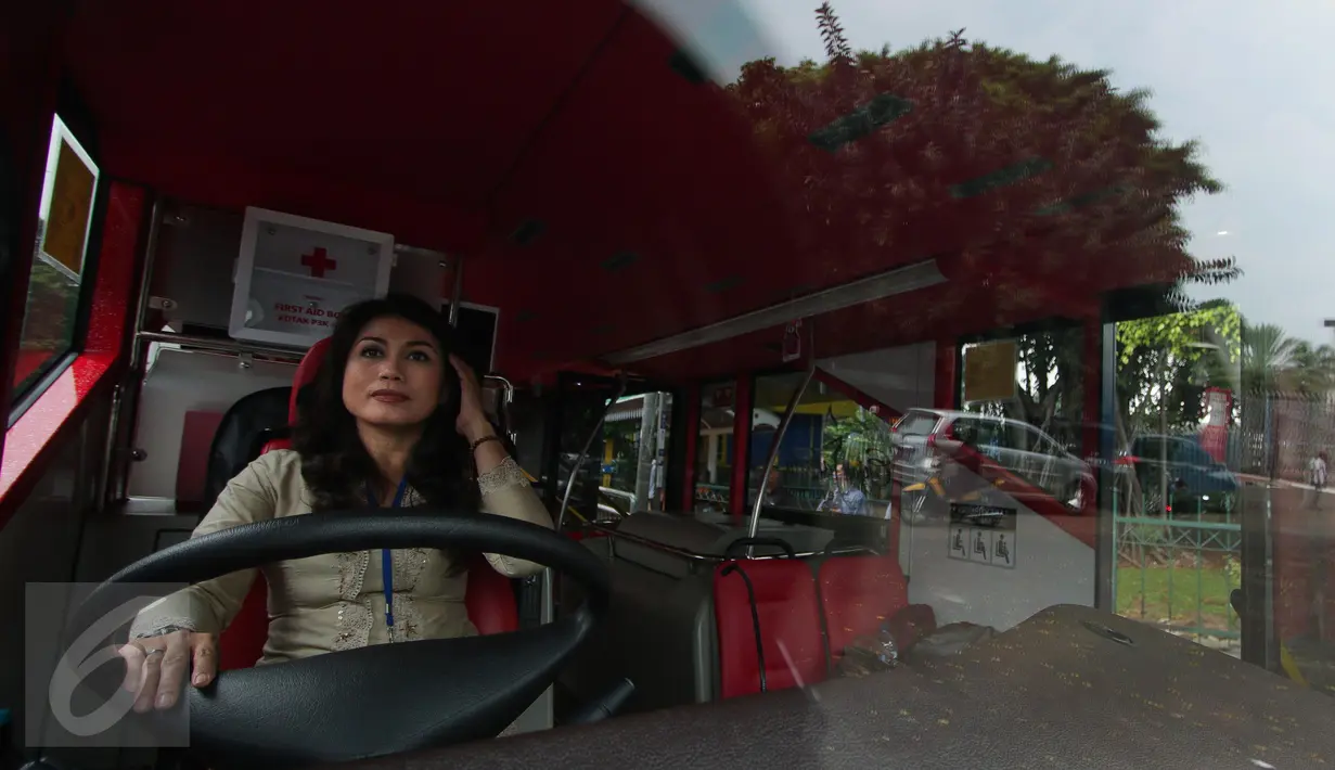 Pramudi bus tingkat wisata TransJakarta mengenakan kebaya saat menjalankan tugasnya di Jakarta, Jumat (21/4). Dalam rangka Hari Kartini, semua pramudi perempuan bus pariwisata dan Transjakarta mengenakan kebaya. (Liputan6.com/Faizal Fanani)