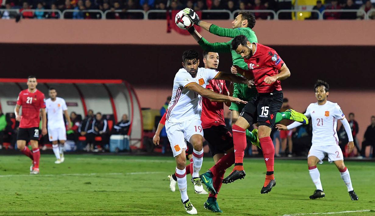 Kiper Albania, Etrit Berisha, mengamankan bola dari serangan pemain Spanyol. Kekalahan ini membuat Albania tertahan di posisi tiga klasemen sementara dengan enam poin. (AFP/Andrej Isakovic)