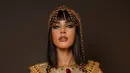 Dibalut busana keemasan berhiaskan permata warna-warni, Tasya tampil bagai Cleopatra yang bangkit di era digital. Namun highlight utama dari penampilannya jelas terletak pada makeup mata yang sangat rapi dan dramatis.  [@tasyafarasya].