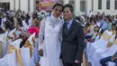 Pasangan suami istri berfoto usai mengikuti pernikahan massal di Managua, Nikaragua, Selasa  (14/2/2023). Acara tersebut diselenggarakan oleh stasiun radio Sandinista "La Nueva Radio Ya", dan sekitar 263 pasangan menikah di Lapangan Revolusi. (AP Photo/Inti Ocon)