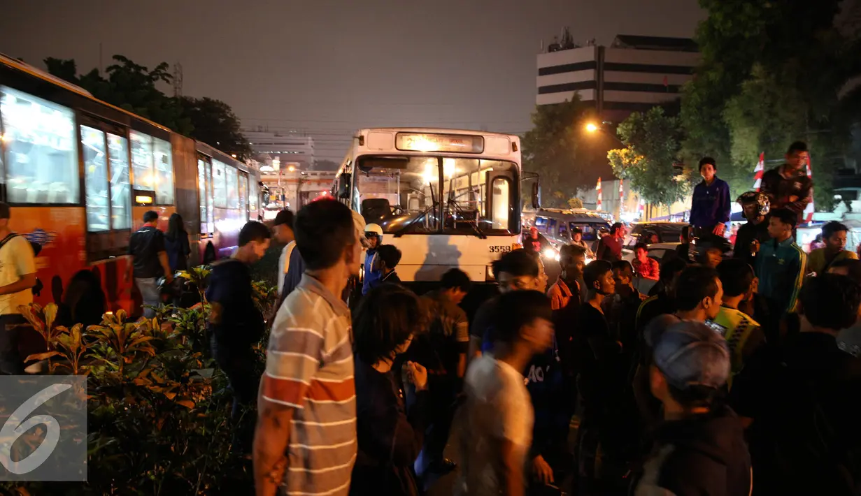 Sejumlah warga mengerumuni pria tanpa identitas yang sekarat usai di tabrak bus PPD 213 di kawasan Matraman Raya, Jakarta, Kamis (20/8/2015). Menurut saksi pria tersebut nekat menyeberang melewati jalur busway. (Liputan6.com/Faizal Fanani)