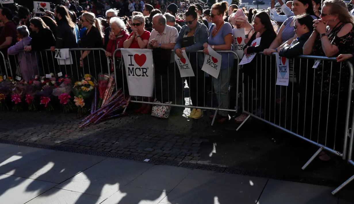 Sejumlah orang menghadiri aksi solidaritas di Albert Square, pusat kota Manchester, sehari setelah teror bom bunuh diri saat konser Ariana Grande, Selasa (23/5). Mereka membawa bendera kecil, poster bertuliskan I Love MCR. (AP Photo / Kirsty Wigglesworth)