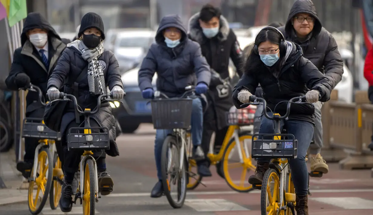 Para komuter yang mengenakan masker untuk melindungi diri dari COVID-19 mengendarai sepeda di Beijing, China, Rabu (15/12/2021). China mendeteksi kasus kedua varian omicron pada seorang pria berusia 67 tahun yang dinyatakan positif setelah lebih dari dua minggu karantina.(AP Photo/Mark Schiefelbein)