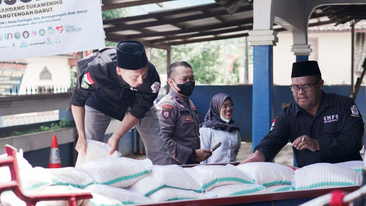 Beberapa jemaah thoriqoh qodariyah wanaqsabandiyah (TQN) Suryalaya yang tergabung dalam pengurus GMPS Suryalaya Cabang Garut, Jawa Barat tengah membagikan  bantuan di lokasi banjir bandang Karangtengah, Garut.