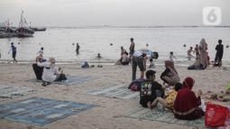 Pengujung berwisata di Pantai Ancol, Jakarta, Rabu (28/12/2022). Isu cuaca yang kurang bersahabat pada hari ini, tidak menyurutkan keinginan warga menghabiskan libur untuk berwisata di kawasan wisata Ancol. (Liputan6.com/Faizal Fanani)