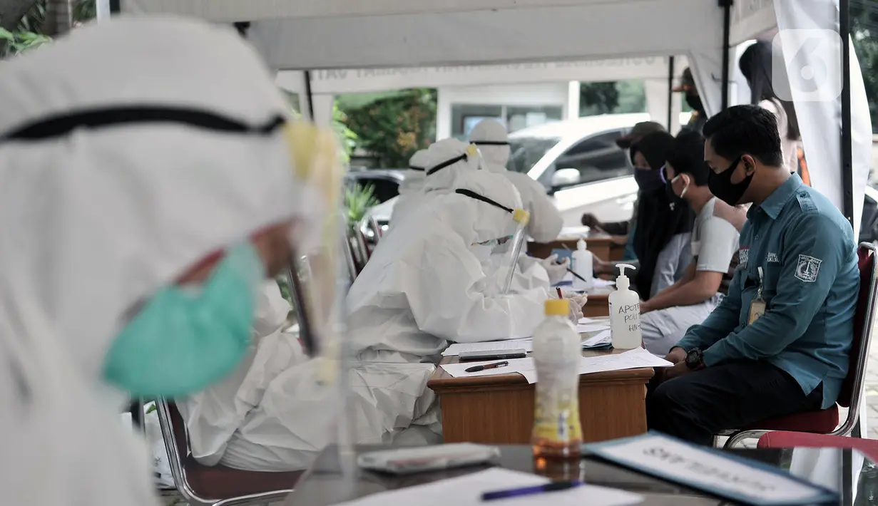 Petugas medis mendata peserta sebelum menjalani tes swab COVID-19 di Kantor Kecamatan Kramat Jati, Jakarta, Selasa (16/6/2020). Puskesmas Kecamatan Kramat Jati menggelar tes swab bagi seluruh pegawai instansi pemerintahan untuk memutus rantai penyebaran COVID-19. (merdeka.com/Iqbal Nugroho)