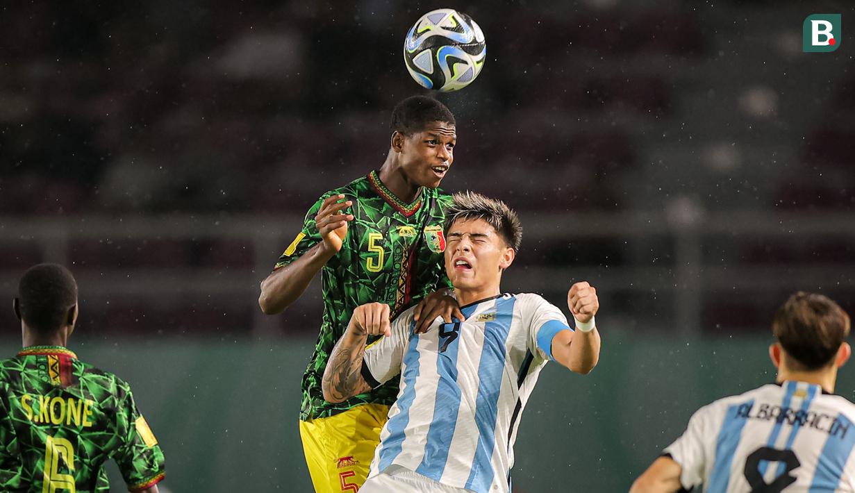 <p>Pemain Timnas Mali U-17, Issa Traore (atas) memenangi duel udara dengan pemain Timnas Argentina U-17, Agustin Ruberto pada laga perebutan tempat ketiga Piala Dunia U-17 2023 di Stadion Manahan, Solo, Jumat (1/12/2023). (Bola.com/Bagaskara Lazuardi)</p>