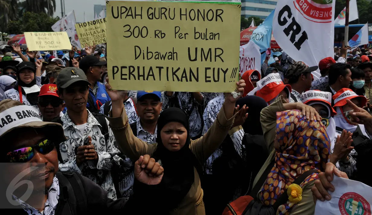 Pengunjuk rasa membawa karton bertuliskan tuntutan mereka saat menggelar aksi mogok dan unjuk rasa di depan gedung DPR/MPR, Jakarta, Selasa (15/9). Para guru honorer itu menuntut Pemerintah mengangkat mereka menjadi PNS. (Liputan6.com/Johan Tallo)