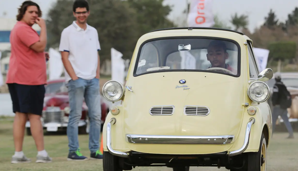 Seorang pria mengendarai mobil model BMW Isetta kuning klasik selama pertemuan klasik Kairo ke-7 di Kairo, Mesir (23/3). Pertemuan ini menjadi ajang nostalgia bagi para pecinta mobil klasik. (Reuters/Mohamed Abd El Ghany)