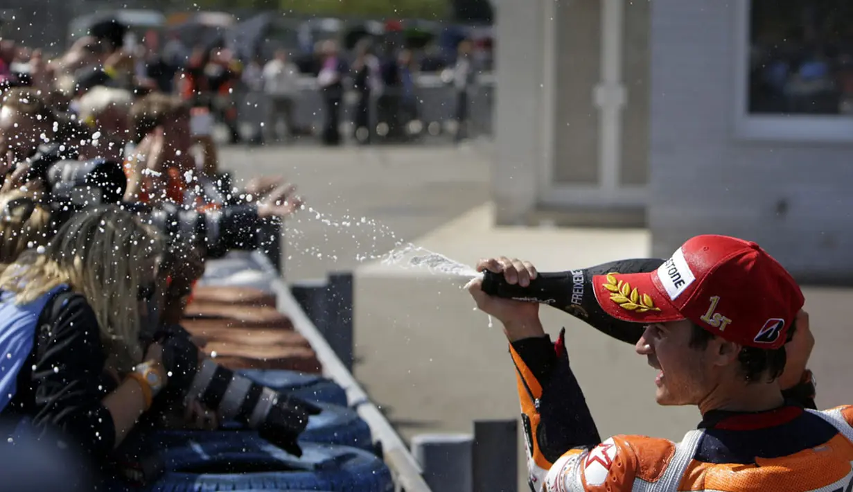 Dani Pedrosa (depan) menyemprotkan sampanye ke arah fotografer usai meraih podium utama GP Ceko 2014 di Sirkuit Brno, (17/8/2014). (REUTERS/David W Cerny)
