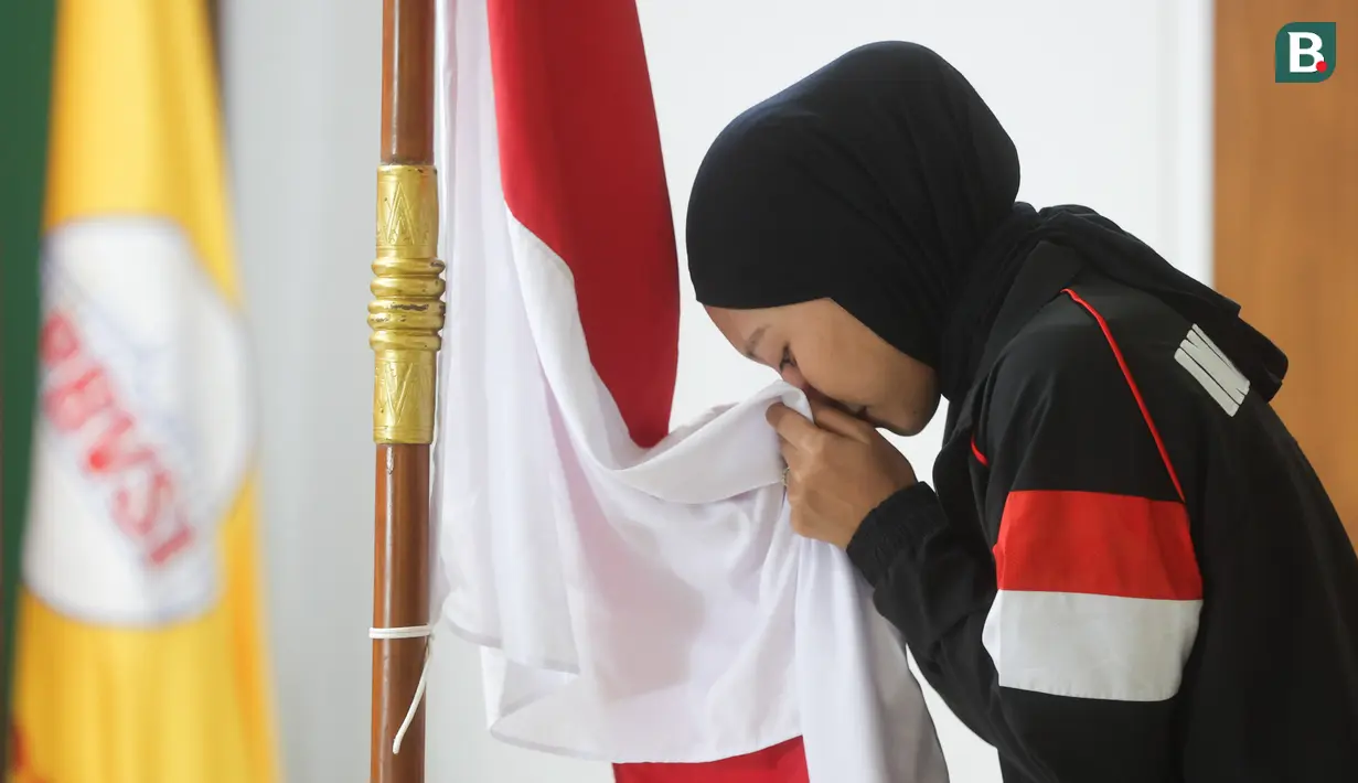 Pemain menyium bendera Merah Putih saat acara pelepasan Timnas Voli Putri Indonesia untuk mengikuti ajang AVC Nations Cup 2025 di Padepokan Bola Voli Jenderal Polisi Kunarto, Sentul, Bogor. Rabu (4/6/2025). (Bola.com/M Iqbal Ichsan)