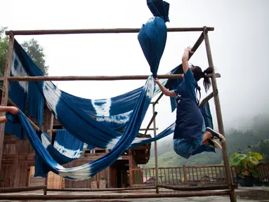 Dua orang perempuan menjemur kain di sebuah bengkel kerja di Desa Etnis Dong Fengdeng di Wilayah Rongjiang, Provinsi Guizhou, China pada 6 September 2020. Warga setempat memanfaatkan kondisi cuaca musim gugur yang mendukung untuk membuat kain tradisional kelompok etnis Dong. (Xinhua/Liu Xu)