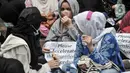 Pencari suaka asal Afghanistan membawa poster tuntutan di depan Kantor UNHCR, Jakarta, Senin (15/11/2021).  Ratusan pencari suaka tersebut menuntut segera dipindahkan ke negara ketiga yang terbebas dari konflik perang setelah lebih 10 tahun mengungsi di Indonesia. (merdeka.com/Iqbal S Nugroho)