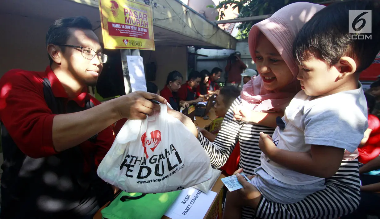 Panitia AGP membagikan paket sembako kepada warga kurang mampu di Rawa Badak Selatan, Jakarta Utara, Kamis (13/6). Kegiatan ini digelar untuk meringankan beban keuangan masyarakat kurang mampu yang tidak melakukan mudik lebaran.  (Liputan6.com/HO/Rizki)