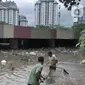 Petugas Pusat Pengelolaan Kompleks (PPK) Kemayoran membersihkan sampah yang muncul akibat banjir di Underpass Kemayoran, Jakarta, Minggu (2/2/2020). Selain melumpuhkan akses, banjir setinggi hingga 5 meter tersebut menyebabkan sampah memenuhi Underpass Kemayoran. (merdeka.com/Iqbal S. Nugroho)