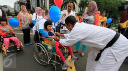 Seorang anak disabilitas mendapat balon saat mengikuti Jalan Sehat Keluarga Disabilitas (JSKD) di Pasar Akhir Pekan SCBD, Jakarta (11/12). (Liputan6.com/Fery Pradolo)
