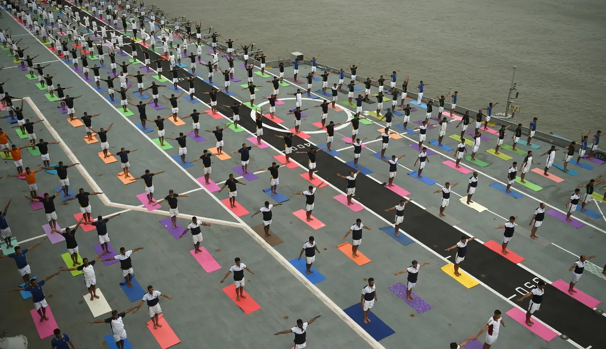 Sejumlah Personel Angkatan Laut India melakukan gaya yoga di atas kapal induk INS Viraat pada Hari Yoga Internasional di atas kapal induk INS Viraat di pelabuhan Mumbai, India, (21/6). (AFP Photo/Punit Paranjpe)