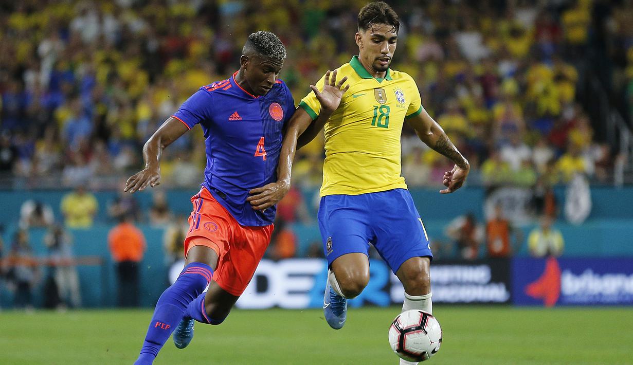 Gelandang Kolombia, Luis Orejuela, berebut bola dengan gelandang Brasil, Lucas Lima, pada laga persahabatan di Stadion Hard Rock, Florida, Jumat (6/9). Kedua negara bermain imbang 2-2. (AFP/Michael Reaves)
