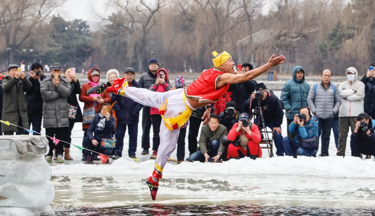 Seorang perenang musim dingin yang mengenakan kostum menyelam ke dalam danau yang sebagian membeku di Shenyang, provinsi Liaoning, China, Selasa (19/2). Mereka percaya berendam di sungai dengan suhu yang ekstrem baik untuk kesehatan. (Photo by STR / AFP)