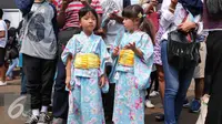 Dua anak menggunakan kimono saat menghadiri festival Jak-Japan Matsuri 2016 di Jakarta, (3/9). Kimono merupakan pakaian khas negeri sakura dan memiliki ciri khas masing-masing yang sering di gunakan oleh para wanita Jepang. (Liputan6.com/Angga Yuniar)