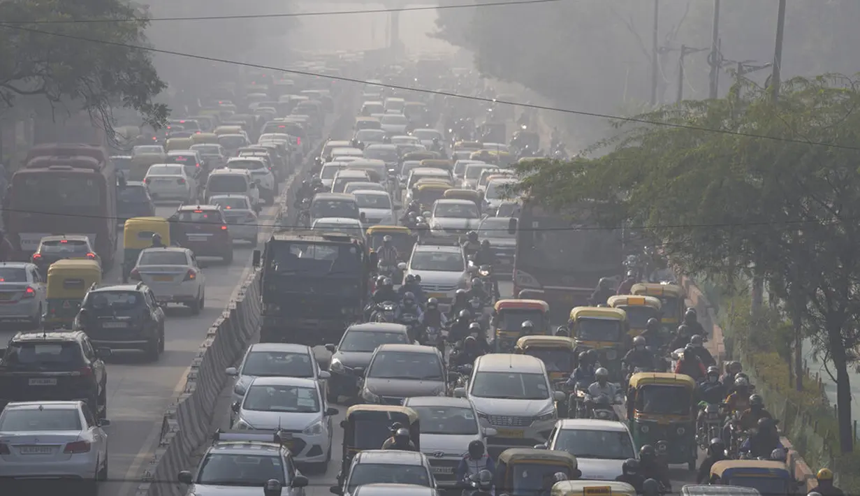 Para komuter berkendara di tengah kabut pagi dan kabut asap beracun di New Delhi, India, 17 November 2021. Tingkat polusi di New Delhi mencapai level yang sangat buruk pada bulan ini. (AP Photo/Manish Swarup)