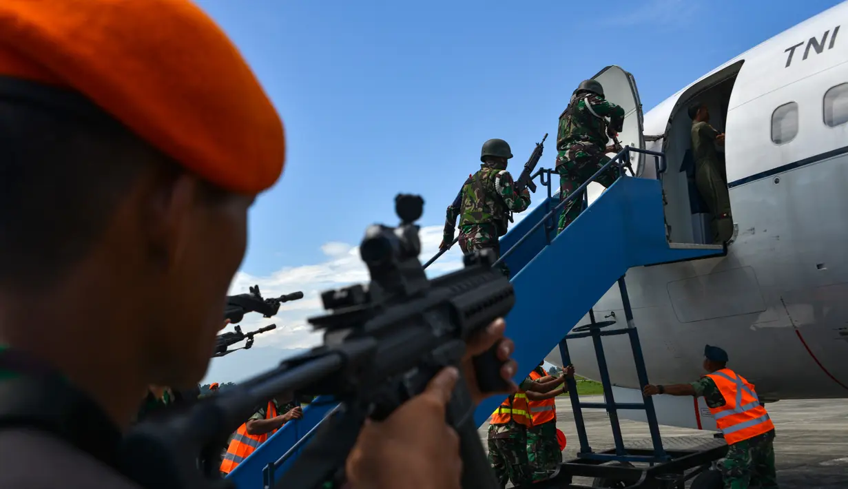 Sejumlah personel TNI AU menaiki tangga saat akan memasuki pesawat saat latihan serangan pesawat di Lanud Sultan Iskandar Muda, Blang Bintang, Provinsi Aceh, Kamis (19/2/2020). (CHAIDEER MAHYUDDIN/AFP)