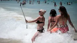 Pengunjung mengabadikan gambar dipinggir pantai Bondi Sydney selama gelombang panas yang melanda wilayah Australia, (20/11/2015). Badan Meteorologi Australia mencatat suhu mencapai lebih dari 40 derajat celsius dan akan meningkat. (REUTERS/Jason Reed)