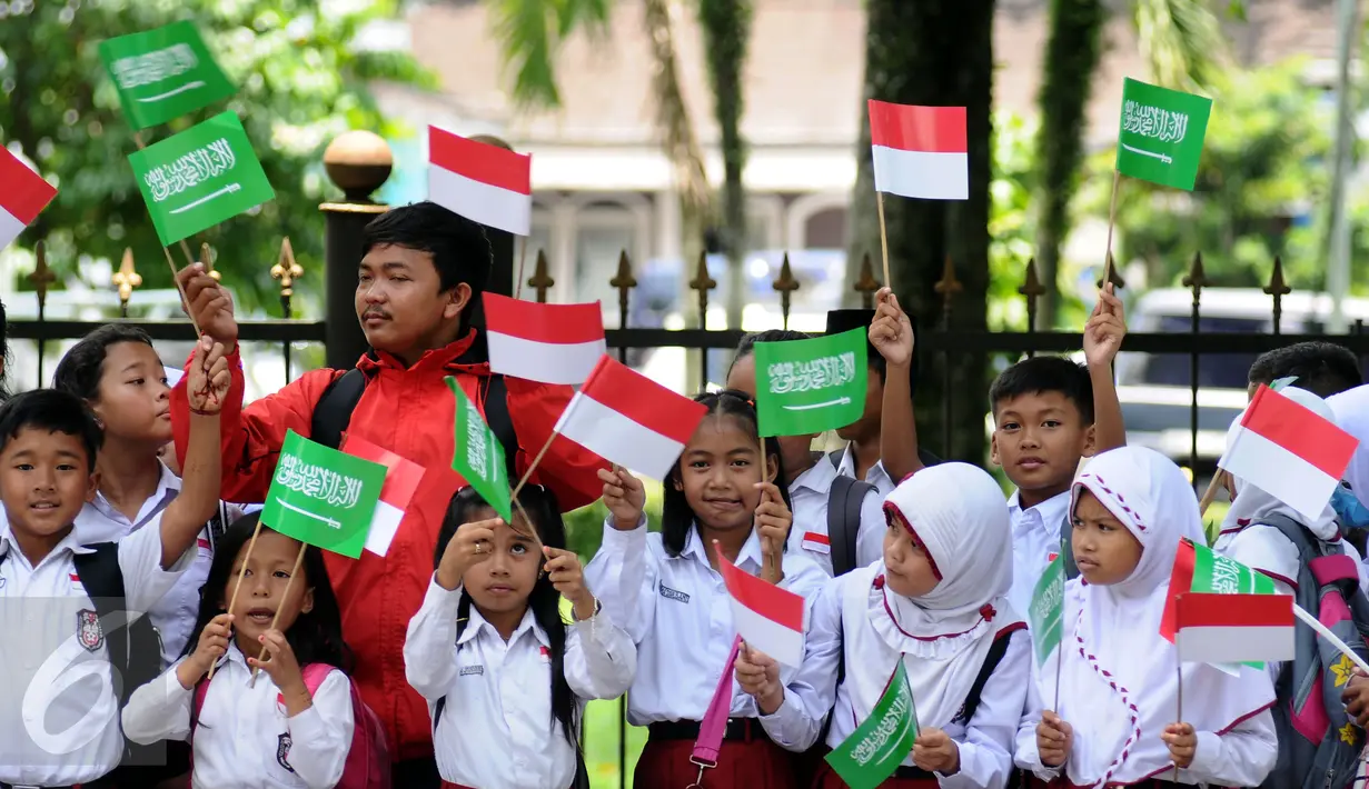 Sejumlah pelajar mengibarkan bendera kedua negara untuk menyambut kedatangan Raja Salman bin Abdulaziz di Istana Bogor, Rabu (1/3). 21 dentuman meriam dan kibaran bendera kedua negara mewarnai sambut Raja Salman. (Liputan6.com/Helmi Fithriansyah)