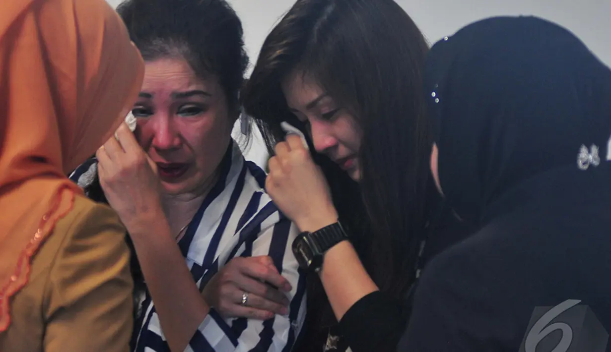 Risma saat mendekati keluarga penumpang yang tidak bisa menyembunyikan kesedihannya karena pesawat  AirAsia QZ8501 belum juga ditemukan, Surabaya, Jawa Timur, Senin   (29/12). (Liputan6.com/Johan Tallo)