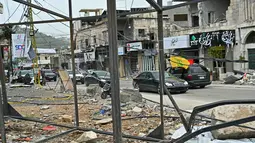 Mereka kembali setelah gencatan senjata sementara selama 10 hari diberlakukan antara Lebanon dan Israel. Tampak dalam foto, warga pengungsi berkendara melewati bangunan-bangunan yang hancur saat mereka kembali ke kota Nabatieh, Lebanon Selatan pada Sabtu 18 April 2026. (FADEL itani/AFP)