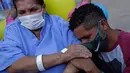 Helena Elvira (63) menerima pelukan dari putranya saat keluar dari rumah sakit di Stadion Nasional Mane Garrincha di Brasilia, Brasil, Kamis (15/10/2020). Rumah sakita darurat tersebut memulangkan tiga pasien COVID-19 terakhir setelah dinyatakan sembuh (AP Photo/Eraldo Peres)