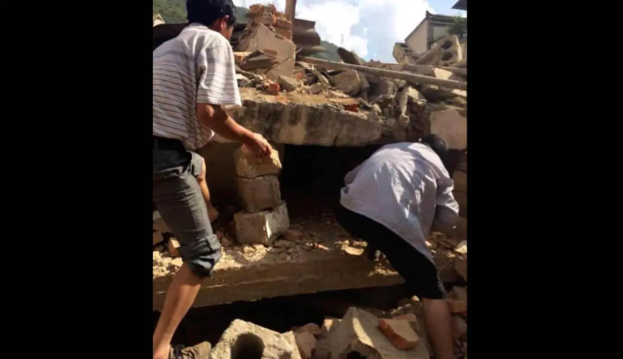 Warga tampak mencoba menyelamatkan korban yang terperangkap puing-puing usai gempa di China, Minggu (3/8/14). (REUTERS/China Daily)