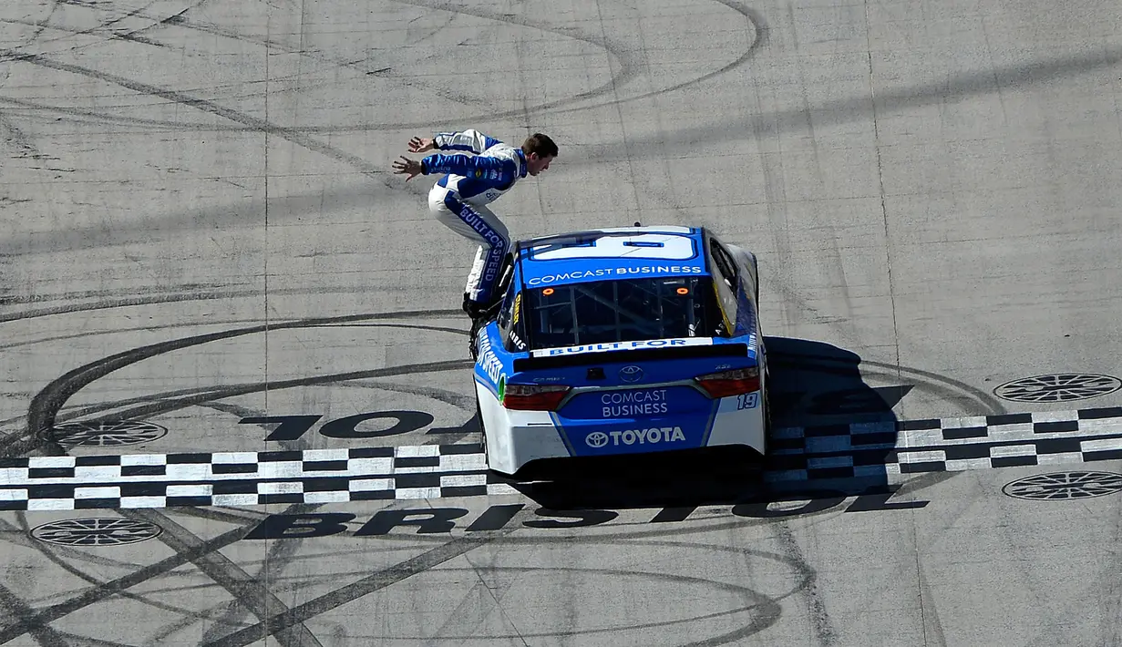 Pembalap Carl Edwards bersiap untuk melakukan aksi berbahaya dengan bersalto dari mobil ketika mesin dalam keadaan berjalan usai merayakan kemenangan NASCAR Sprint Cup Series Food City 500 di Bristol Motor Speedway (17/4). (AFP/Matt Sullivan)