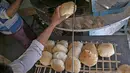 Pria Mesir bekerja di sebuah toko roti di sebuah pasar di Kairo, pada 17 Maret 2022. Melonjaknya harga roti yang dipicu oleh invasi Rusia ke Ukraina telah menggigit daya beli konsumen di Mesir, importir gandum terkemuka dari negara-negara bekas Soviet. (Khaled DESOUKI / AFP)