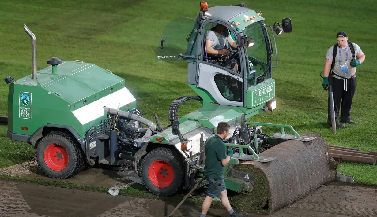 Pekerja menggunakan mesin khusus saat memasang rumput baru lapangan Stade Pierre Mauroy di Lille, Prancis, (23/6). Jelang laga 16 besar dan final Piala Euro 2016 pihak penyelenggara memperbaiki rumput lapangan bola. (REUTERS/Carl Recine)
