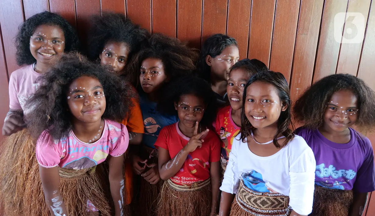 Sejumlah anak-anak berfoto usai mengikuti latihan tari di rumah seni Sawinggrai, Raja Ampat, Papua Barat, Jumat (22/11/2019). Pertamina melalui program tanggung jawab sosialnya membangun Rumah Seni Budaya Sawinggrai pada tahun 2016. (Liputan6.com/Herman Zakharia)