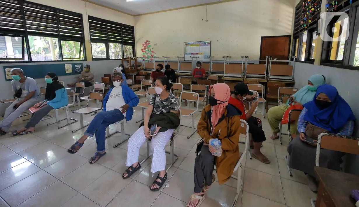 Warga menunggu vaksinasi COVID-19 petugas kesehatan dari Puskesmas Kecamatan Matraman di SD Negeri 25 Utan Kayu Selatan, Matraman, Jakarta Timur, Rabu (23/3/2022). Layanan vaksinasi digelar setiap hari Senin sampai Jumat pukul 08.00-11.00 WIB. (Liputan6.com/Herman Zakharia)