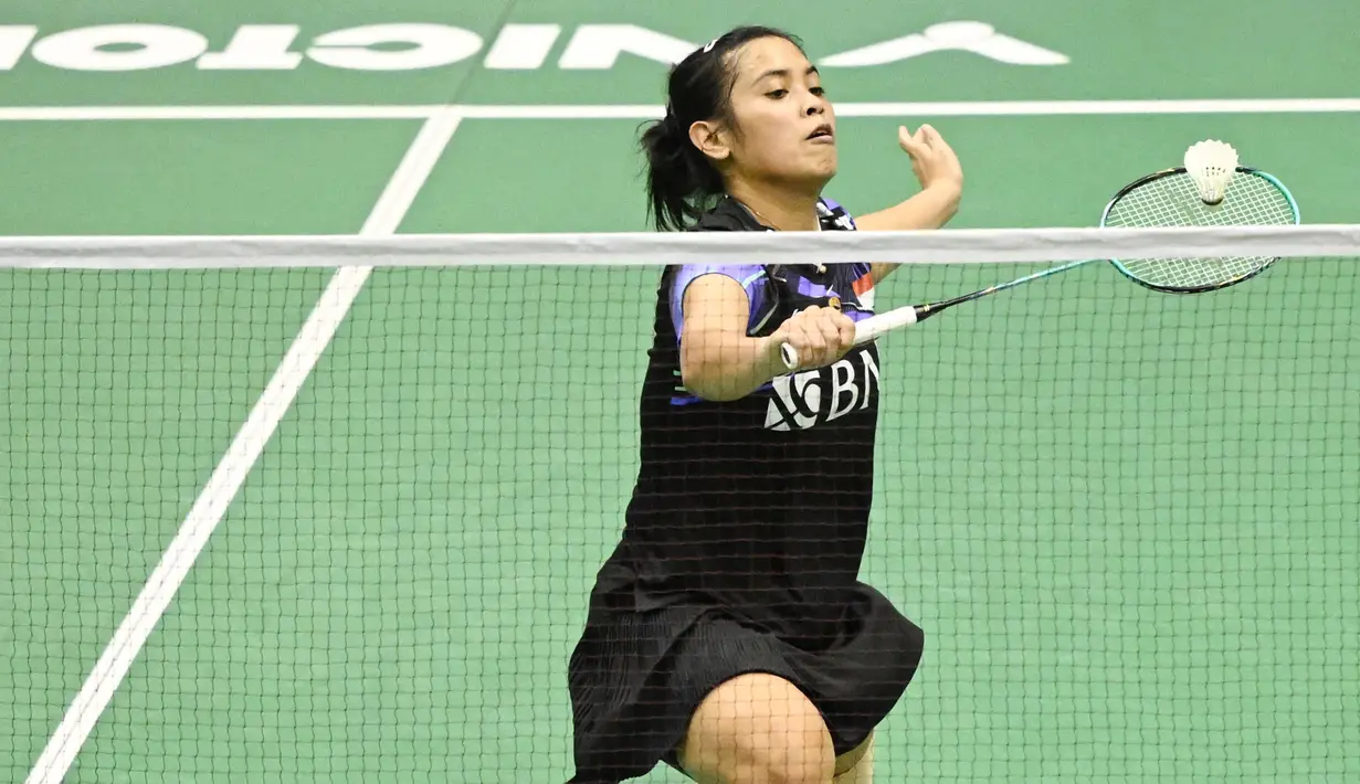 Tunggal putri Indonesia, Gregoria Mariska Tunjung, terjatuh saat berusaha mengembalikan kok melawan wakil Spanyol, Carolina Marin, pada laga perempat final turnamen Hong Kong Terbuka 2023 di Coliseum, Hong Kong, Jumat (15/9/2023). Gregoria menang dua set langsung dengan skor 21-9 dan 21-18. (AFP/Peter Parks)